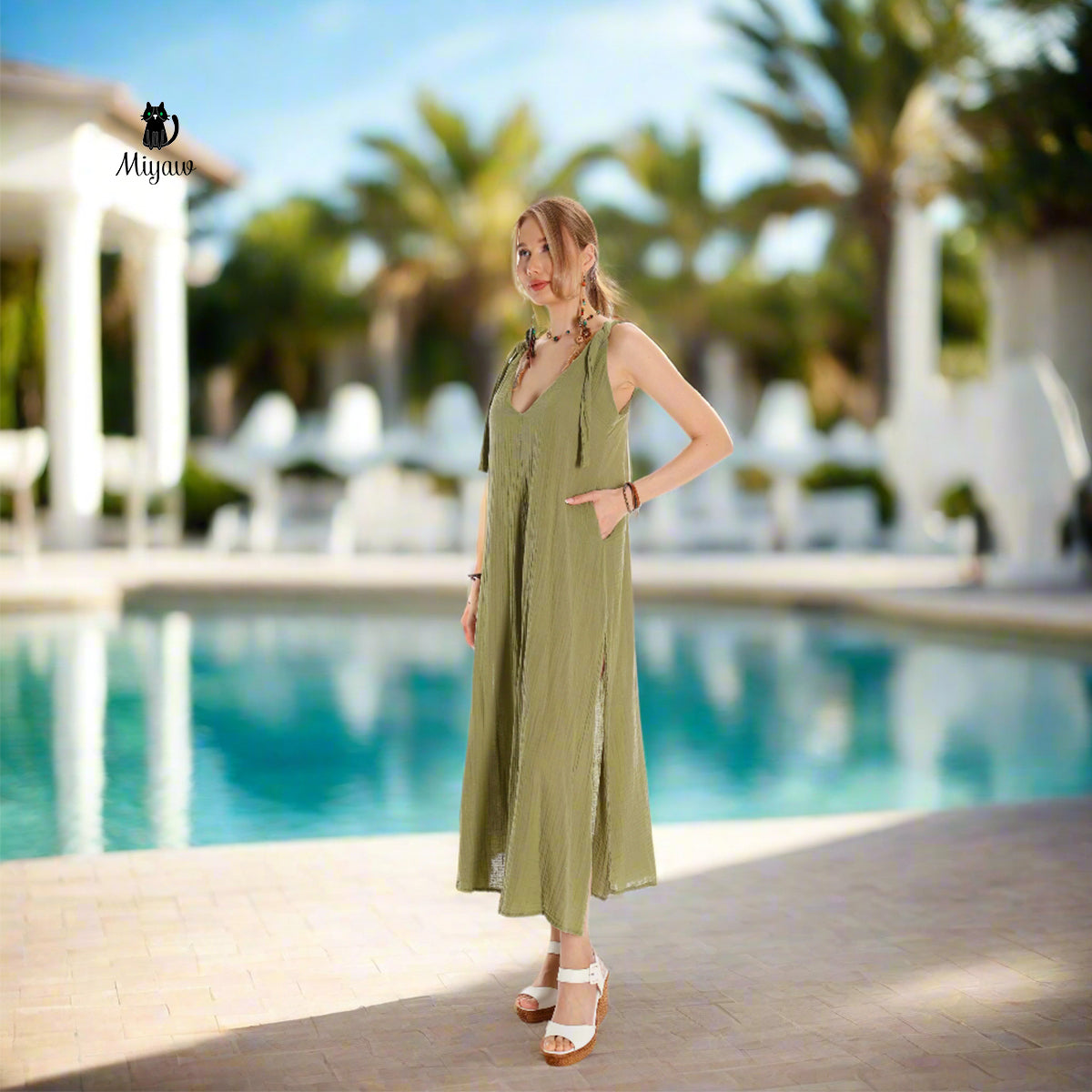 A gorgeous woman wearing a maxi dress stands near the pool at a resort in Rosemary Beach.