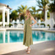 A gorgeous woman wearing a maxi dress stands near the pool at a resort in Rosemary Beach.