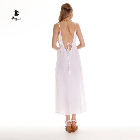 A glorious woman wears a white maxi dress in heels in a jungle