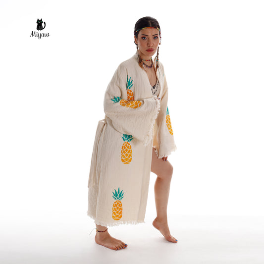 A woman gracefully dons a flowing Boho Pineapple Kimono Robe, her bare feet softly brushing against the ground.A woman is wearing a kimono robe and is barefoot.