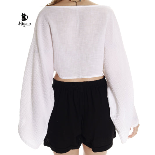 Woman in boho crop top with long sleeves and boat neck