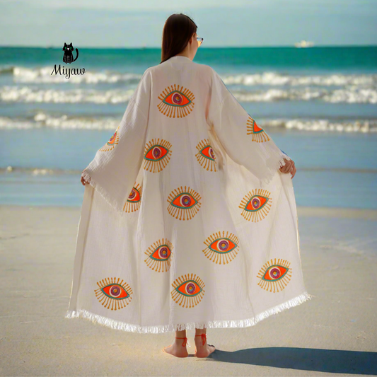 A woman standing on the beach wearing a miyawfashion kimono robe.