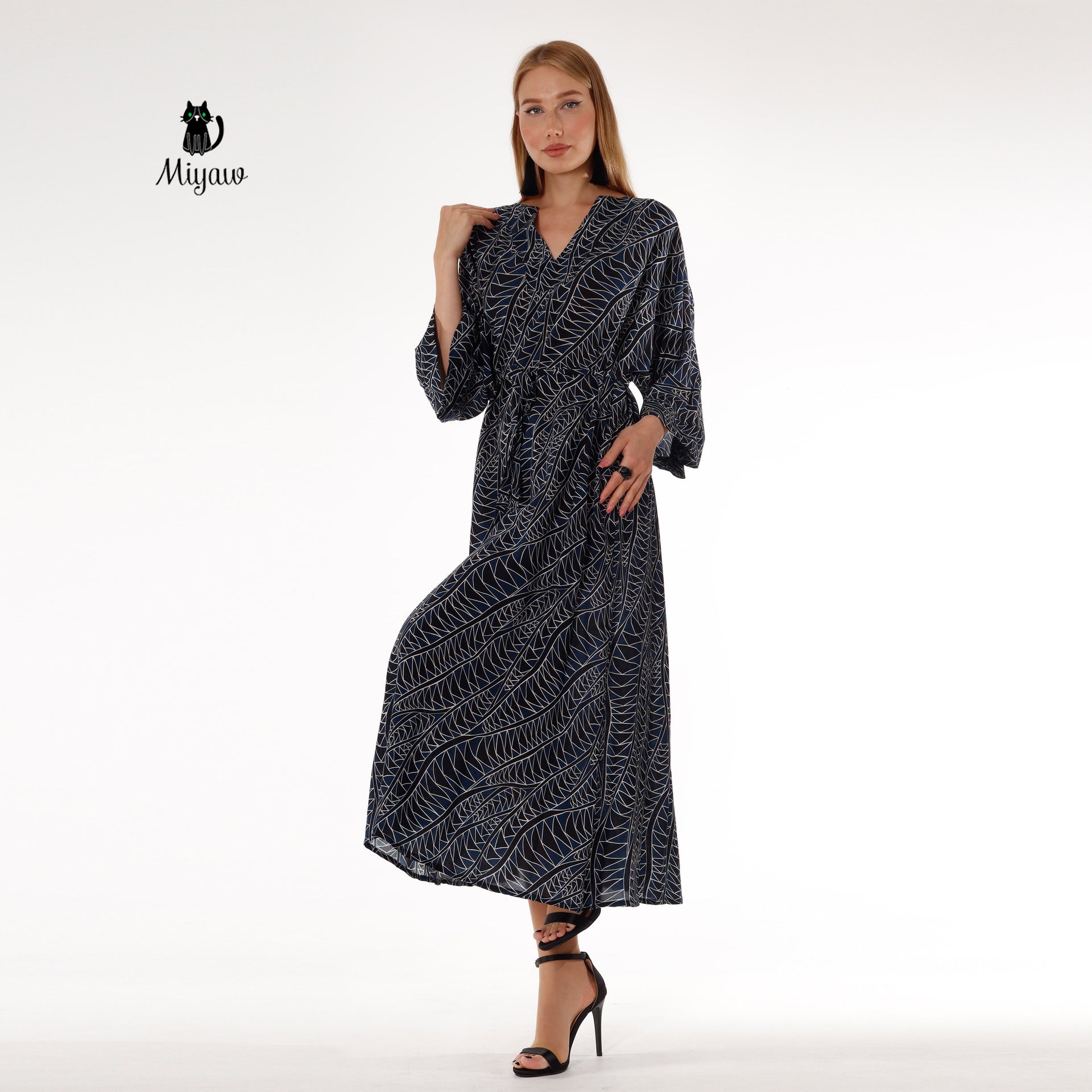 Woman showcasing black long sleeve dress maxi style with bohemian elegance