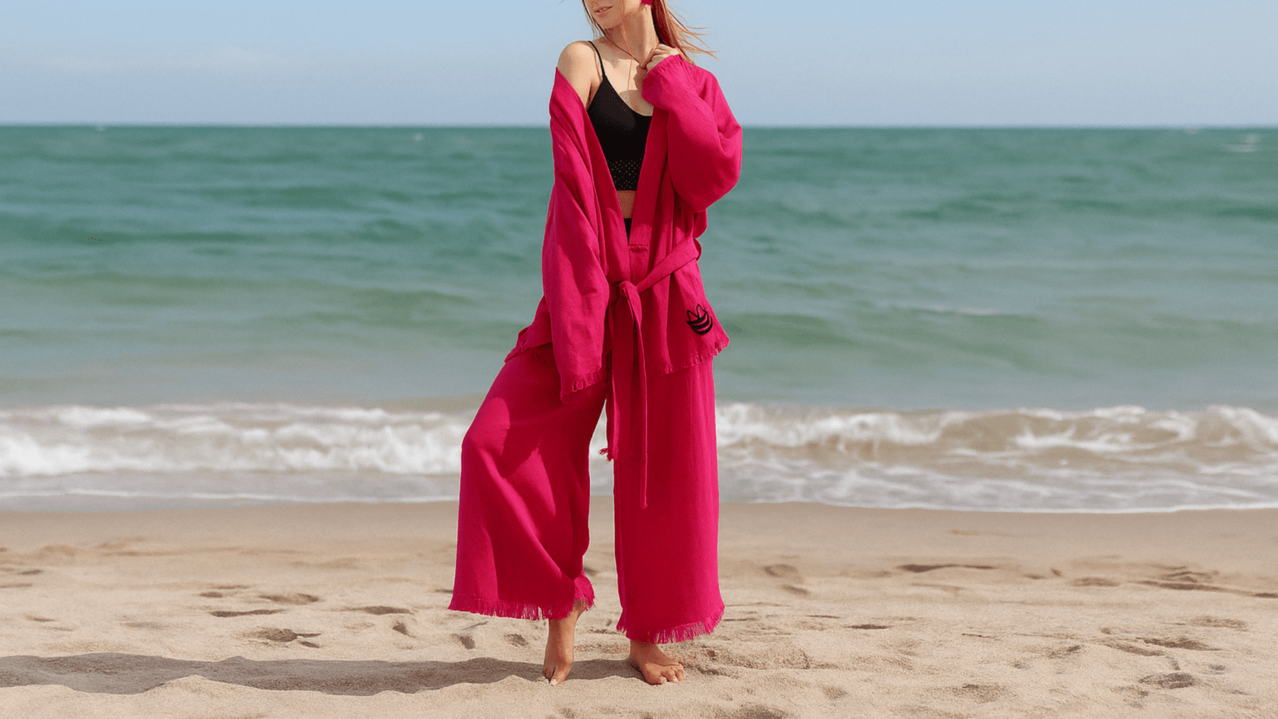 A woman wearing a cotton pajama set is standing in the sea breeze.