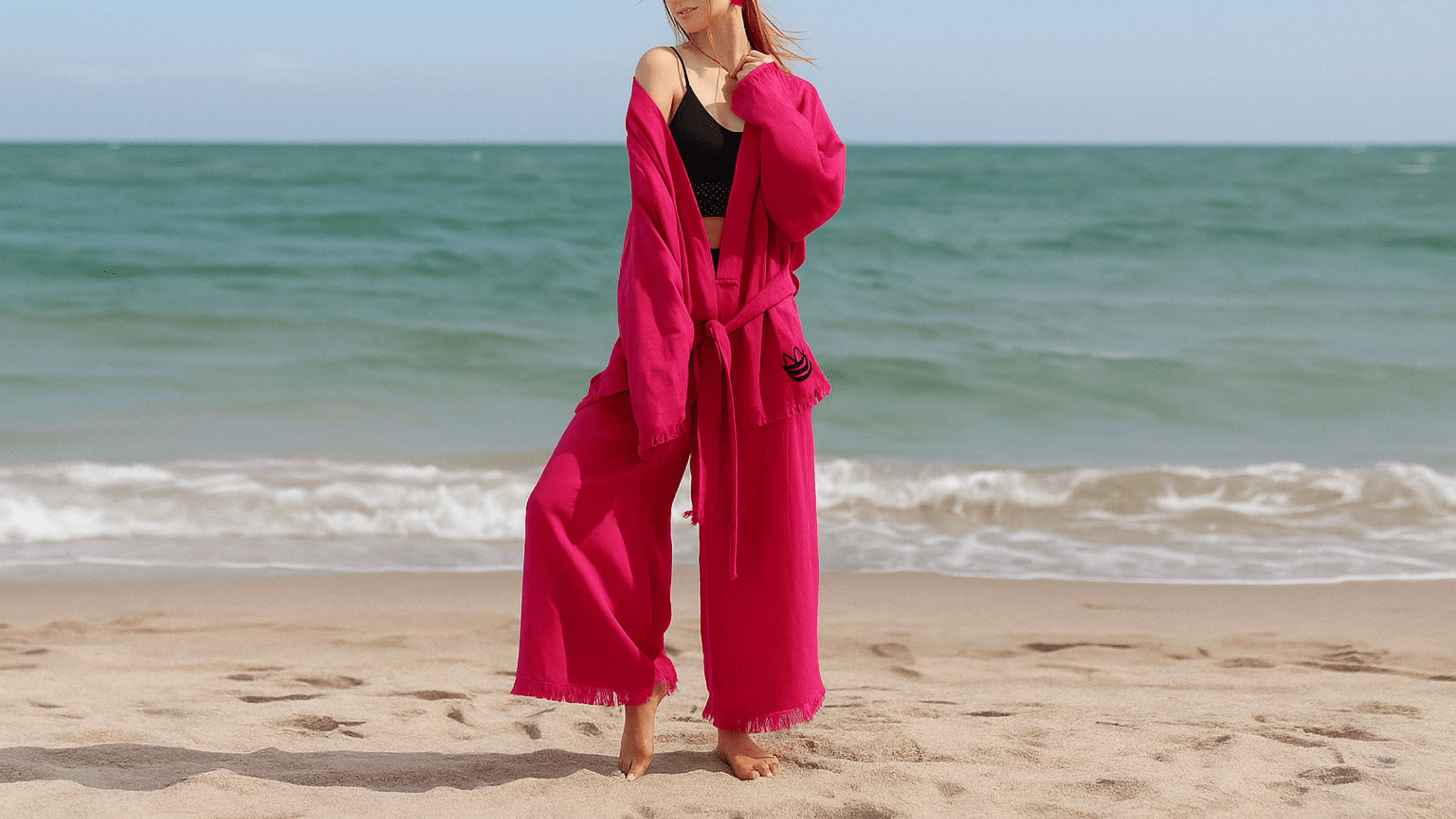 A woman wearing a cotton pajama set is standing in the sea breeze.