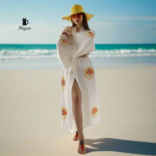 A woman standing on the beach wearing a miyawfashion kimono robe.