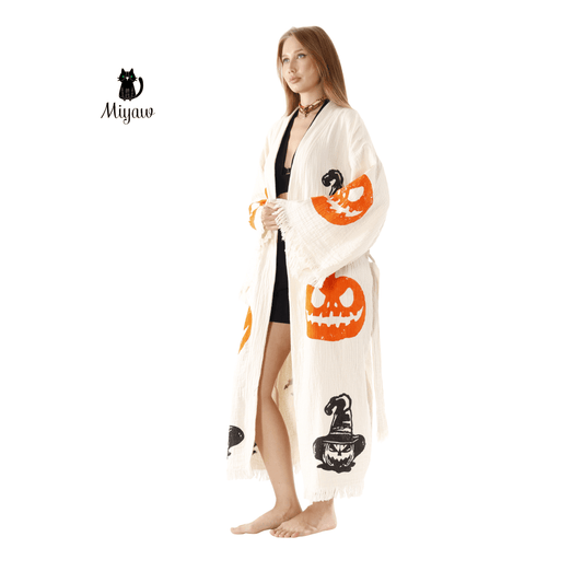 Woman wearing a Halloween-themed cape with pumpkins and bats on a white background