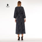 Stylish black long sleeve maxi dress worn by woman, chic resort wear look
