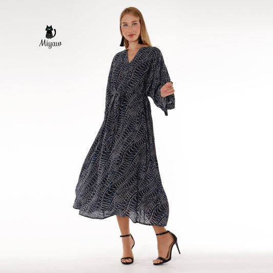 Model wearing a black long sleeve maxi dress with V-neck, perfect for resort vacations
