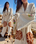 Woman wearing a handmade organic cotton covered up swimwear robe on the beach, styled as an elegant lightweight resort cover up.