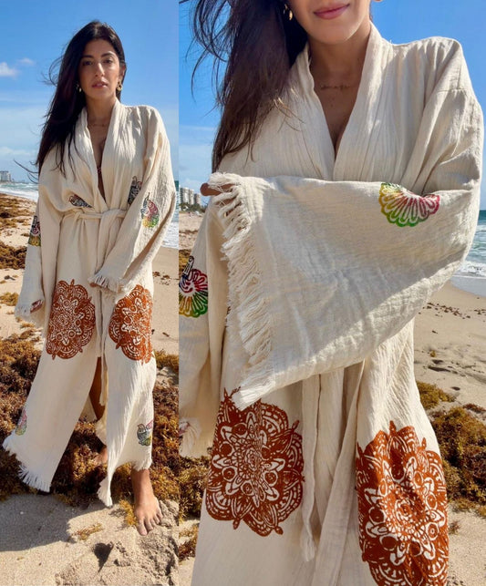 Woman wearing a handmade organic cotton covered up swimwear robe on the beach, styled as an elegant lightweight resort cover up.