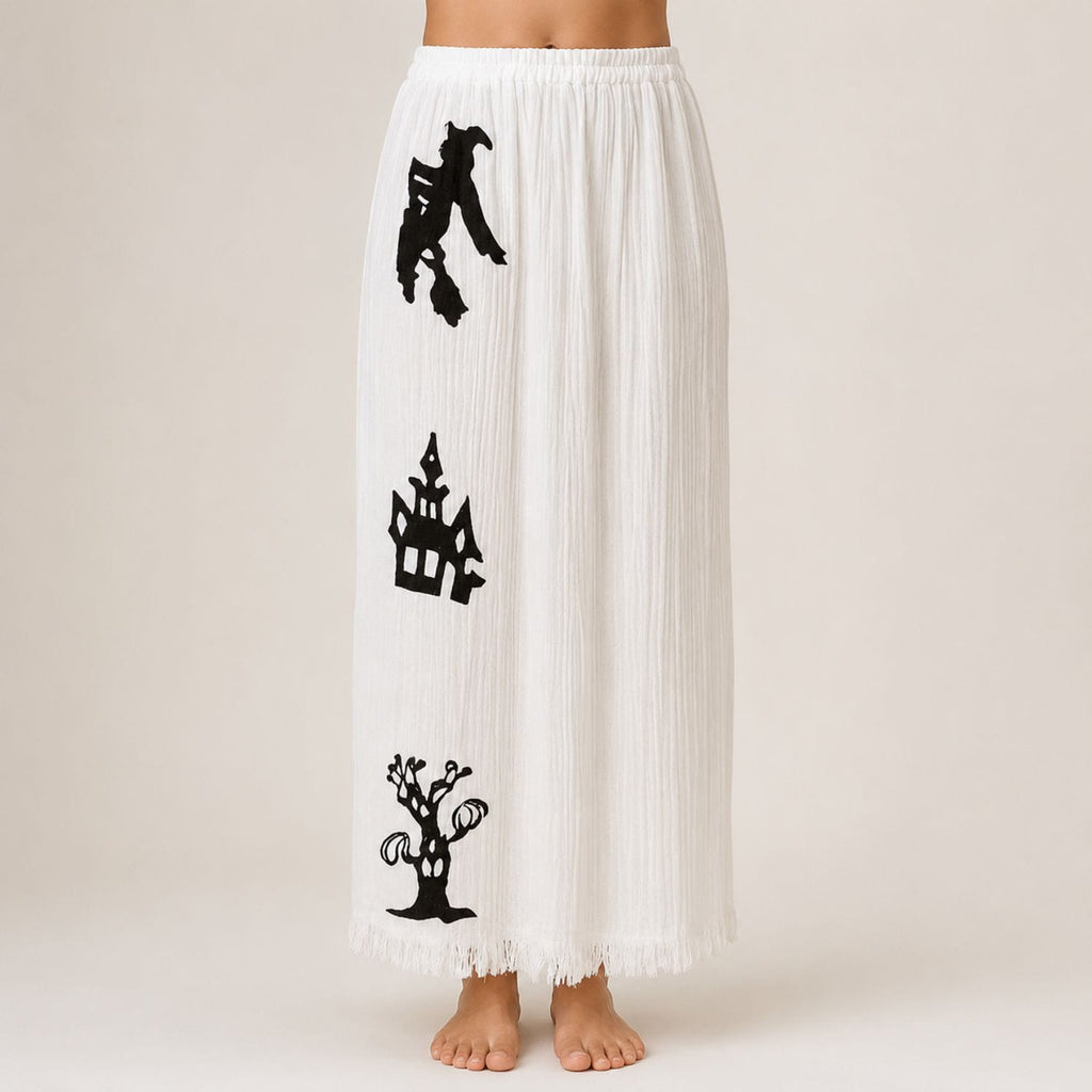White Halloween pajama pants with black witch, haunted house, and spooky tree print.