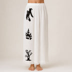 White Halloween pajama pants with black witch, haunted house, and spooky tree print.