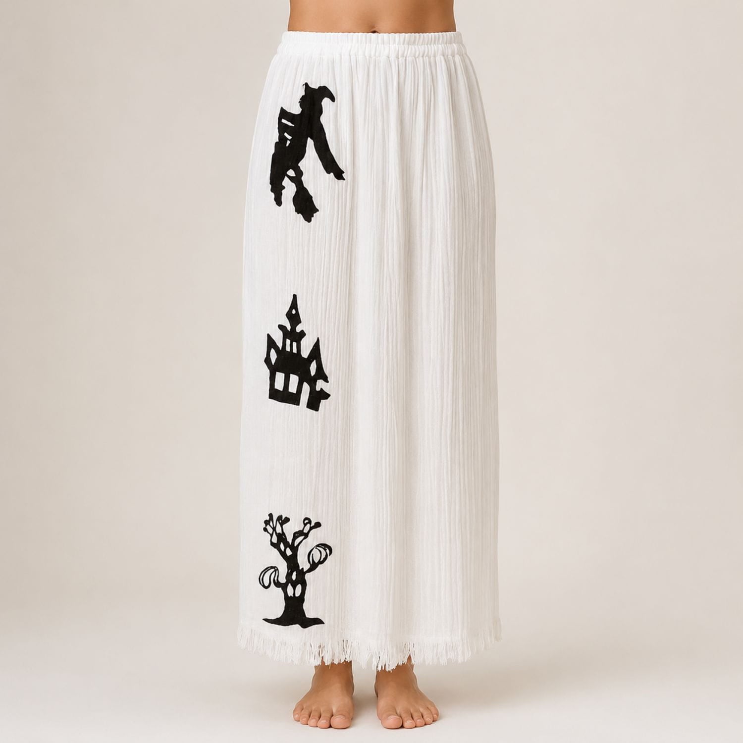 White Halloween pajama pants with black witch, haunted house, and spooky tree print.