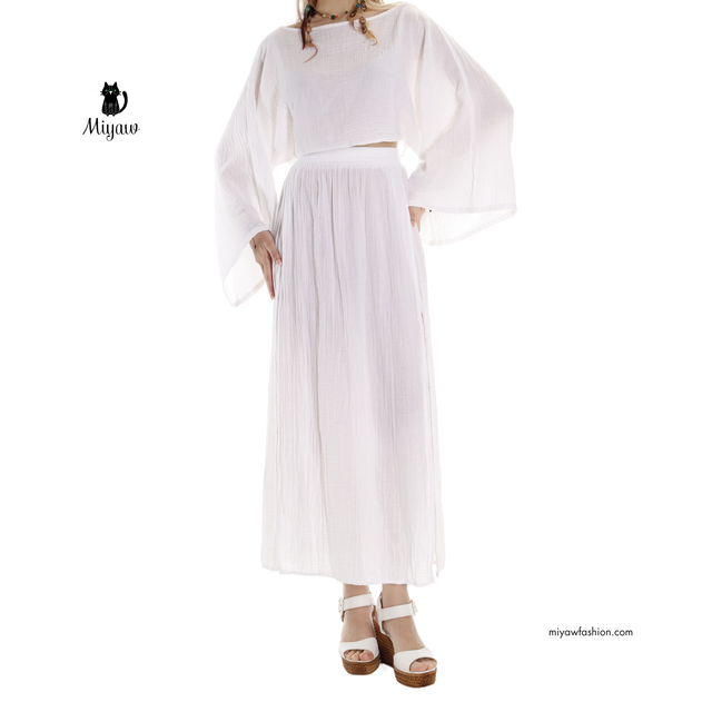 Woman wearing a handcrafted white organic cotton maxi skirt with double front slits styled for boho beach and resort wear by MIYAW Fashion.